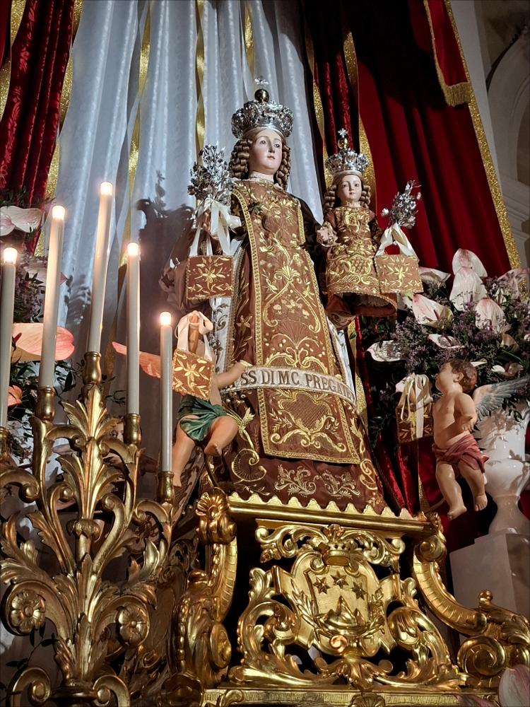<div class="ql-editor"><div>Lo scatto fotografico immortala la sontuosa statua lignea della Madonna del Carmine di Mesagne (BR) risalente al XVII secolo.</div><div>La Festa Patronale della Madonna del Carmine, celebrata dal 15 al 17 luglio fin dal 1651, è uno degli eventi più significativi per la comunità. Non è soltanto una ricorrenza religiosa, ma un rito collettivo che rinnova ogni anno tradizioni, legami e identità.</div><div>Il 15 luglio si svolge la solenne processione che accompagna il simulacro della Vergine dalla Basilica del Carmine alla Chiesa Matrice, alla presenza di confraternite, autorità religiose e civili, bande musicali e numerosi fedeli. In Piazza Porta Grande si tiene il tradizionale discorso dell’Arciprete e del S...