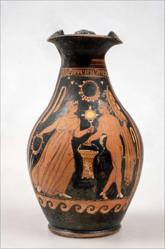 <div class="ql-editor"><div>L’oinochoe appartiene a un gruppo di reperti di generica provenienza da Soleto, entrati nel Museo nella seconda metà dell’Ottocento e acquisiti al patrimonio dell’allora Provincia di Terra d’Otranto. I reperti furono inventariati e sistemati nelle collezioni museali solo all’inizio del 1928, nell’ambito del riordino del Museo. Il vaso presenta un orlo trilobato, un corpo ovoidale, un piede ad anello e un’ansa a nastro. La decorazione raffigura una figura femminile, con stephane e specchio, che avanza verso un giovane satiro con himation, situla e tympanon. La scena è racchiusa tra motivi decorativi a ovuli e onde correnti e arricchita da elementi sovradipinti, tra cui nastri, corone e fiori....