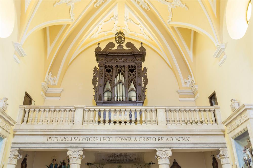 L'organo rappresentato nell'immagine digitale è collocato nella chiesa di S. Michele Arcangelo a Patù, in provincia di Lecce. La chiesa fu edificata dall’architetto Francesco Centolanze di Nardò nel 1584. La chiesa, ad aula unica, conserva all’interno gli altari dedicati a S. Michele, S. Francesco, la Madonna del Rosario e la Madonna del Carmine. È inoltre presente una statua di San Michele che viene portata ogni anno in processione. La cassa d’organo è collocata in una cantoria posizionata in controfacciata e completamente rifatta come ricorda l’iscrizione lungo il basamento: “PETRAROLI SALVATORE LECCI DONATA A CRISTO RE A.D. MCMXL”. Divisa in tre campate nel prospetto anteriore a quattro pilastri, i laterali più grandi e scolpiti con motivi ornamentali a basso rilievo...