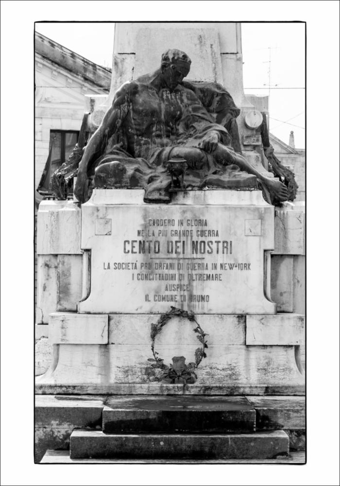 L'immagine digitale mostra un primo piano del gruppo scultoreo del Monumento ai Caduti di Grumo Appula. Posto al centro di Piazza Vittorio Veneto, il monumento è in pietra, marmo e bronzo di tipo "a cippo" e fu realizzato dallo scultore barese Mario Sabatelli negli anni '20, su commissione dell'Amministrazione comunale cofinanziato dalla comunità dei conterranei residenti negli Stati Uniti con 35.000 Lire. Fu scelta, come si evince dalle fonti dell'epoca, l'opera del Sabatelli perché rispecchiava i valori storici e filosofici richiesti dalla committenza e il profondo senso di riconoscenza verso i Caduti e il trionfo della Vittoria. La fotografia è stata esposta nel Salone degli Affreschi del Palazzo Ateneo di Bari per la mostra fotografica “La memoria della Grande Guerr...