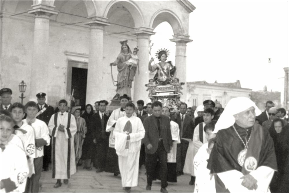In questa foto storica la statua di San Primiano Martire esce dalla Chiesa SS. Maria Annunziata, mentre la processione prende avvio per le strade del paese.
La festa patronale di San Primiano Martire è una celebrazione religiosa e popolare che si svolge ogni anno a Lesina (FG), dal 14 al 16 maggio. Al centro vi è il culto del santo, le cui reliquie giunsero a Lesina nel IX secolo da Larino, luogo del suo martirio nel 303 d.C.
Le celebrazioni comprendono la traslazione del simulacro alla Chiesa Madre, solenni funzioni liturgiche, la processione per le vie cittadine e la suggestiva processione sul Lago di Lesina, con la benedizione delle acque e dei pescatori.
Il culto si radicò a Lesina nel IX secolo, quando i monaci benedettini portarono qui le reliquie per salvarle dal...