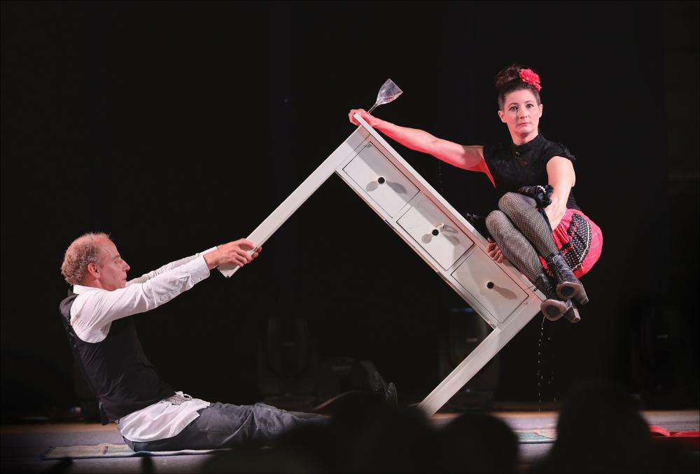 <div>Lo scatto documenta l’esibizione della compagnia svizzera E1NZ (Esther e Jonas Slanzi) durante il Circonauta Festival 2024, con lo spettacolo “Le Bistro”, andato in scena la sera del 6 luglio 2024 in Piazza Vescovato a Nardò (LE). Presenza ormai consolidata del festival, E1NZ si distingue per la raffinata fusione tra teatro e circo contemporaneo.</div><div>Le Bistro è un vecchio ristorante che riecheggia i fasti del passato, ormai prossimo alla chiusura. Tra tavoli e ricordi si muove un cameriere irascibile che incrocia il cammino di una signora stravagante: da questo incontro nasce un microcosmo surreale, un vero e proprio parco giochi per conflitti, gag e numeri acrobatici eccentrici. Attraverso una sapiente miscela di linguaggio teatr...