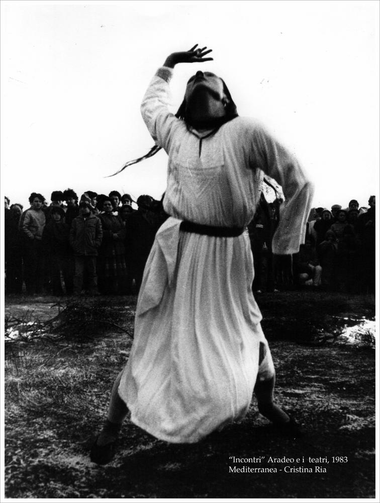 L'immagine digitale cattura uno dei momenti della performance di danza di Cristina Ria, messa in scena a luglio del 1983 nell'ambito della rassegna “Aradeo e i Teatri” inaugurata in quell'anno con il titolo “Incontri”, un appuntamento con il teatro sperimentale. La manifestazione fu organizzata dal circolo culturale “S.M. Ejzenstein” per colmare, attraverso la messa in scena di spettacoli di teatro e danza, la mancanza di confronto fra culture differenti molto sentita dalla cittadinanza di Aradeo. Giorgio Di Lecce e Cristina Ria furono tra i primi a fare ricerca sul campo per riportare la tradizione nella vita di tutti i giorni. Difficile risulta scindere il ruolo dei teatranti, dei performers, degli artisti di strada e dei ricercatori in quanto proprio la  loro poliedr...