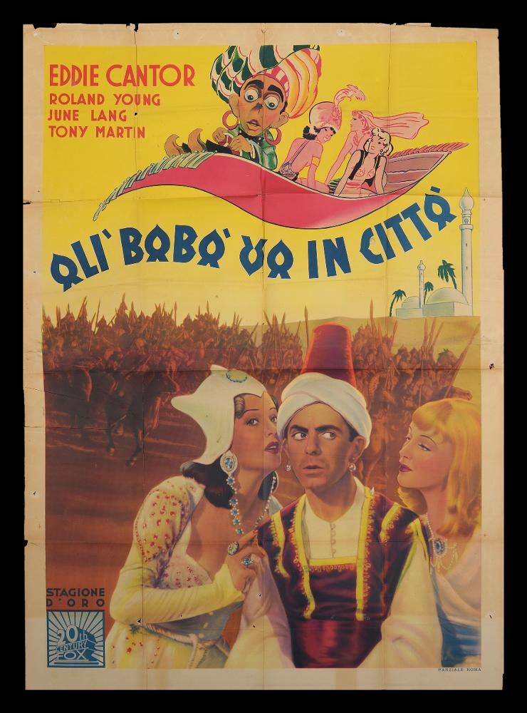 L'immagine riproduce uno dei manifesti conservati presso la Mediateca Regionale Pugliese (vedi Note). Si tratta del manifesto del film in bianco e nero "Alì Babà va in città” del 1937, per la regia di David Butler. Il manifesto, pur non presentando alcuna firma, possiede alcune delle caratteristiche dei manifesti degli stessi anni. Vi possiamo notare tre blocchi narrativi, differenti per stile: in primo piano una scena del film che vede rappresentati Eddie Cantor nei panni di Alì Babà/Aloysius "Al" Babson al centro fra le due protagoniste femminili. Sullo sfondo giallo appare immediatamente l’ambientazione essendoci delle abitazioni che richiamano la tipica architettura islamica come le cupole e delle torre che potrebbero appartenere ad una moschea. In alto, su un tappe...