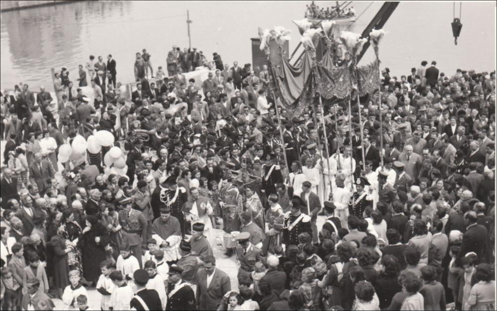 <div class="ql-editor"><div>Questa foto storica digitalizzata, databile agli anni '60, immortala un momento solenne della Festa Patronale del Santissimo Crocifisso di Colonna a Trani, l'arrivo del Crocifisso nel porto accolto da una folla di devoti.</div><div>Questo festeggiamento rappresenta uno degli appuntamenti religiosi e civili più sentiti dalla comunità di Trani (BT), espressione profonda della fede e dell’identità cittadina.</div><div>Fulcro della celebrazione è il venerato Crocifisso ligneo custodito nel Santuario di Colonna, legato a un prodigio risalente al 1480, epoca dell’invasione turca in terra d’Otranto e del martirio degli Ottocento Cristiani. Secondo la tradizione, il Crocifisso, trafugato da pirati saraceni, venne...