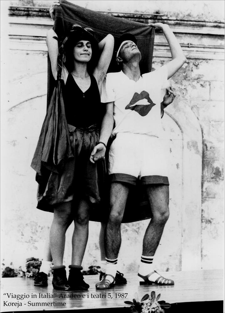 La fotografia in bianco e nero cattura un momento dello spettacolo “Summertime”, messo in scena nel 1987, nell'ambito della rassegna annuale “Aradeo e i Teatri”, un appuntamento con il teatro sperimentale che la compagnia Koreja, nata nel 1983 nel piccolo borgo salentino di Aradeo porta avanti sin dall'anno della sua fondazione. La performance ebbe come palcoscenico il suggestivo cortile del Castello "Tre Masserie", una struttura residenziale degli inizi del XX secolo situato tra gli ulivi della campagna di Aradeo. I personaggi principali della rappresentazione sono “vittime” di un mènage a tre durante le vacanze estive. Una spiaggia, due ragazze terribili e un ragazzo che, pur essendo fortemente attratto da loro, tenta in ogni modo, quasi con disperazione, di allontana...