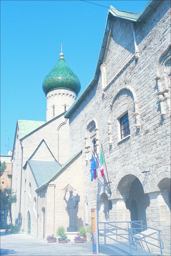 La fotografia è parte della ricca raccolta fotografica “Puglia per tutte le Stagioni” vol. 2, prodotta dall'Assessorato al Turismo e Industria Alberghiera della Regione Puglia, per raccontare la Puglia attraverso immagini suddivise in 5 settori principali: Città e Paesi, Settimana Santa, Territorio, Feste – Sagre – Tradizioni, Mercati – Prodotti – Cucina. Comunemente conosciuta dai baresi come "Chiesa russa", l'edificio religioso nell'immagine è intitolato a San Nicola ed è situato in corso Benedetto Croce a Bari. La sua costruzione risale al 1911, quando venne istituito il Comitato di Bari con a capo il principe A. A. Širinskij-Šichmatov, esperto di arte russa antica, che commissionò la realizzazione di una chiesa e foresteria italiana per i pellegrini russi. Ad Alekse...