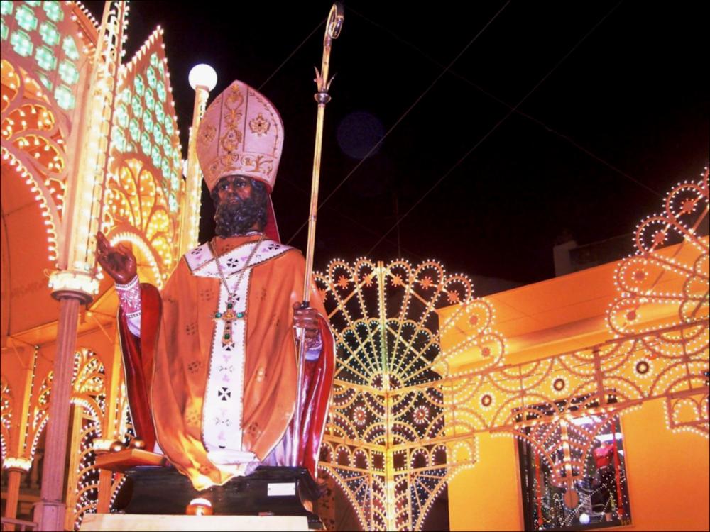 <div class="ql-editor"><div>Lo scatto fotografico mostra in primo piano il busto devozionale di San Nicola Vescovo in processione per le vie cittadine di Aradeo illuminate in occasione della Festa Patronale in onore del Santo.</div><div>La festa dedicata a San Nicola Vescovo, patrono di Aradeo, rappresenta un importante momento di devozione e partecipazione comunitaria. Le celebrazioni comprendono la novena liturgica nei giorni precedenti la festa, la processione per le vie del paese e numerosi eventi civili, tra cui manifestazioni musicali, culturali e artigianali.</div><div>La secolare devozione della comunità di Aradeo verso San Nicola, vescovo di Myra, trova una significativa testimonianza nella cappella di San Nicola di Myra, situata lungo la strada che conduc...