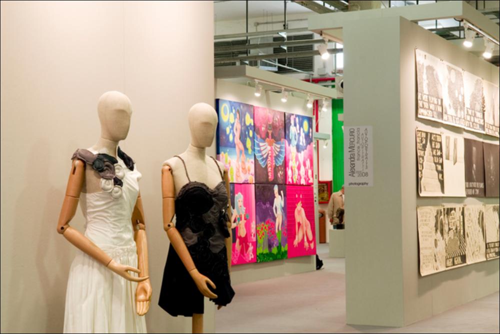 L'immagine digitale documenta un momento della "Biennale dei Giovani Artisti dell'Europa e del Mediterraneo" che, nella sua XIII edizione, fu ospitata in Puglia, a Bari, dal 22 al 31 maggio 2008 negli spazi della Fiera del Levante. La Biennale è considerata la più importante vetrina in Europa e nel Mediterraneo per la creatività delle giovani generazioni. Voluta da Regione Puglia e dall'Associazione Internazionale BJCEM e realizzata dal Teatro Pubblico Pugliese, la Biennale ha dato così spazio ad una visione multidisciplinare, multiforme e internazionalizzata dell'arte contemporanea attraverso creazioni di musica, arti visive, moda, teatro, video, arti applicate, letteratura e gastronomia. Scattata a luce ambiente in uno degli spazi della Fiera, la fotografia rende part...