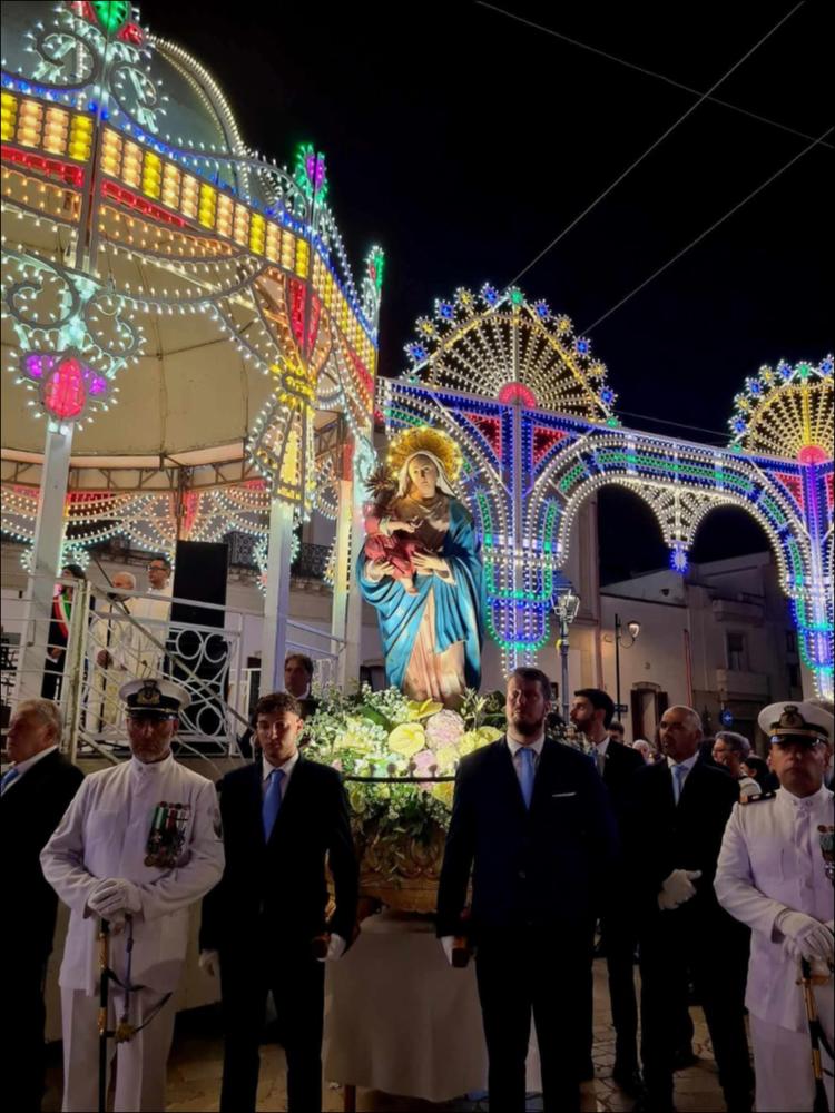 <div class="ql-editor"><div>Lo scatto immortala la Statua della Madonna col Bambino portata in solenne processione in occasione della festa Patronale delle Madonna delle Grazie a Collepasso (LE), un momento caratterizzante ed identitario per la comunità che si festeggia sin dal 1835, come testimoniano gli archivi storici.</div><div>La Patrona si onora sia con celebrazione religiose, quali la Santa Novena, Sante Messe e la Processione, che con celebrazioni civili, quali concerti bandistici, fiera-mercato, spettacoli pirotecnici, concerti con artisti di fama nazionale.</div><div>Ultimamente la festa patronale si sta caratterizzando anche per la promozione di prodotti agroalimentari pugliesi, unendo cultura, turismo religioso ed enogastronomico.</div></div>