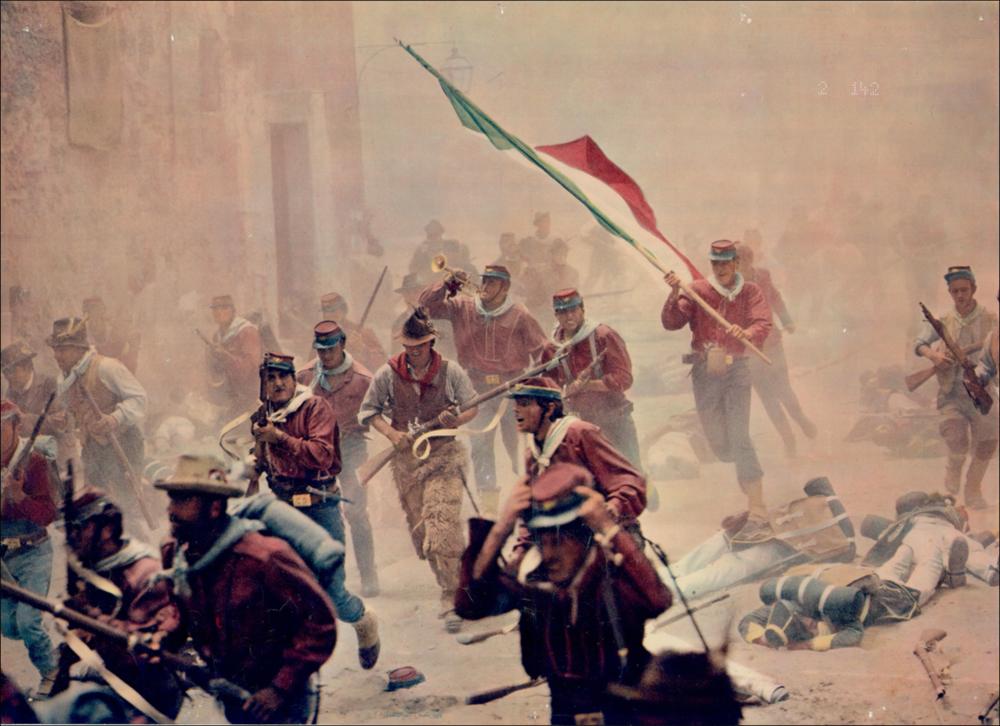 L'immagine digitale è un ritaglio della riproduzione fotografica della fotobusta de “Il Gattopardo” elaborata in occasione della mostra "Cinema 150 anni. Mostra di manifesti cinematografici d'epoca sul Risorgimento", utilizzato per realizzarne cartoline promozionali. La mostra, allestita negli spazi della Mediateca Regionale di Bari, è stata realizzata nel 2011 dall'Ufficio Attività culturali e audiovisivi, afferente al Servizio Cultura e Spettacolo della Regione Puglia, in occasione delle celebrazioni dei 150 anni dell'Unità d'Italia. In questo dettaglio della fotobusta, si restringe il campo e si focalizza l'attenzione dell'osservatore su un momento cardine del film e della storia italiana: l'assalto delle truppe garibaldine a Marsala nel 1860, la conseguente sconfitt...