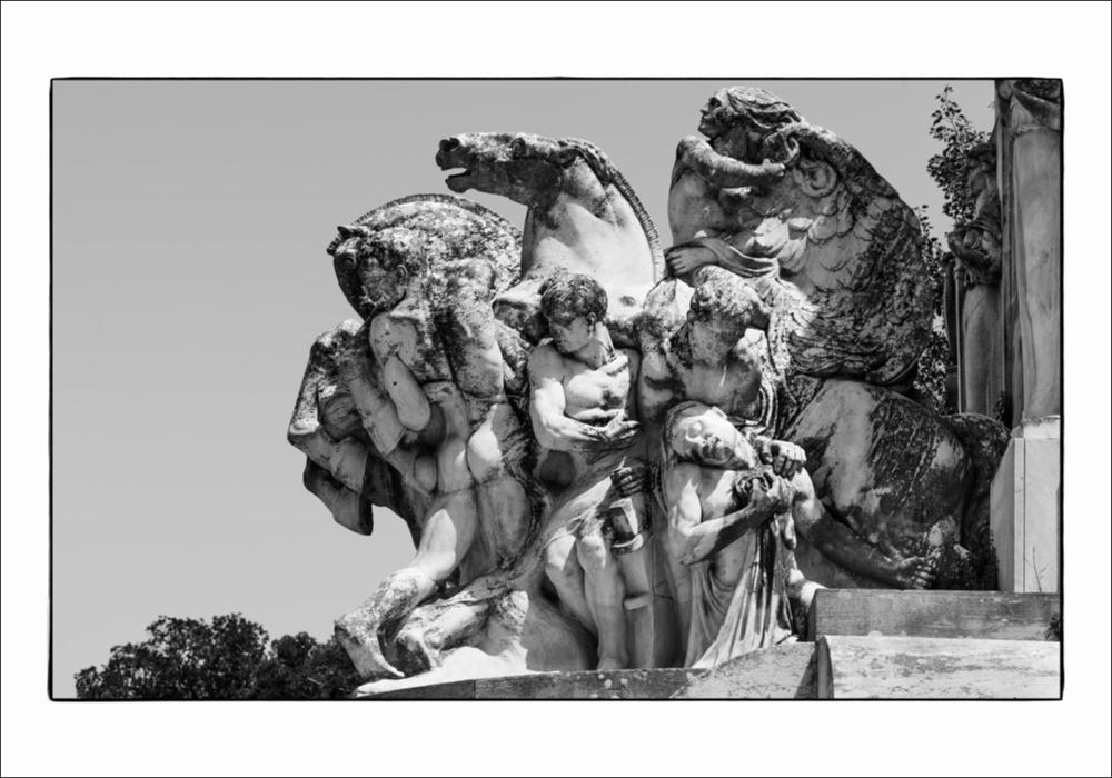 L'immagine digitale mostra un particolare del Monumento ai Caduti a Martina Franca. Opera dello scultore pugliese Antonio Bassi il monumento, sito in Piazza Vittorio Veneto, presenta un maestoso stilobate su cui poggia il grande obelisco. Nello specifico la fotografia riprende un dettaglio del gruppo scultoreo in pietra di Trani, definito dallo stesso autore degli “Eroi”, raffigurante una scena di battaglia che vede protagonisti un gruppo di soldati e due cavalli nell'atto di impennarsi. La fotografia è stata esposta nel Salone degli Affreschi del Palazzo Ateneo di Bari per la mostra fotografica “La memoria della Grande Guerra in Puglia”, a cura di Isabella Di Liddo con foto di Roberto Sibilano, presentata in occasione del Convegno Nazionale di Studi "L'Italia, La Pugli...