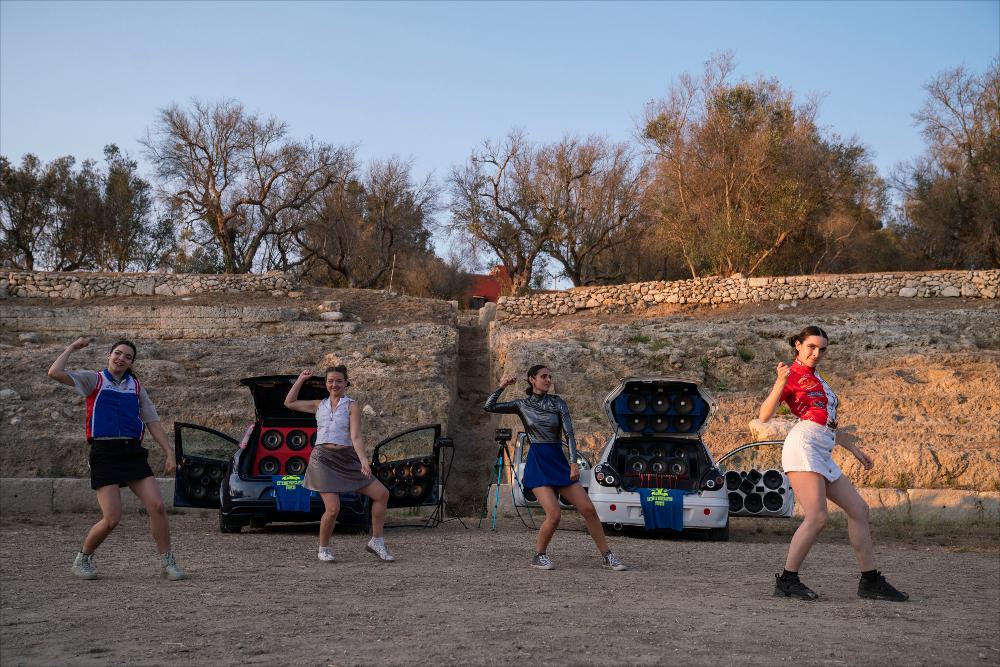 <div>La foto mostra un momento dello spettacolo “<em>Speeed + What Will Happen Tomorrow”</em> di <strong>Parini Secondo </strong>(collettivo artistico) e <strong>Bremo </strong>(duo musicale), presentato al <strong>Parco Rudiae</strong> per il <em>Teatro dei Luoghi – Festival internazionale</em>. <em>Speeed</em> è un progetto coreografico e musicale ispirato al fenomeno della Para Para e dell’Eurobeat, diffusosi nei club di Tokyo negli anni ’90, una centrifuga di puro e genuino entusiasmo. <em>What Will Happen Tomorrow</em> è invece una rock opera spudoratamente pop: un sogno da stadio, tra vibrazioni infernali e sguardi taglienti, che invita a riflettere sulle incognite del futuro. La performance vede in scena <strong>Sissj Bassa...