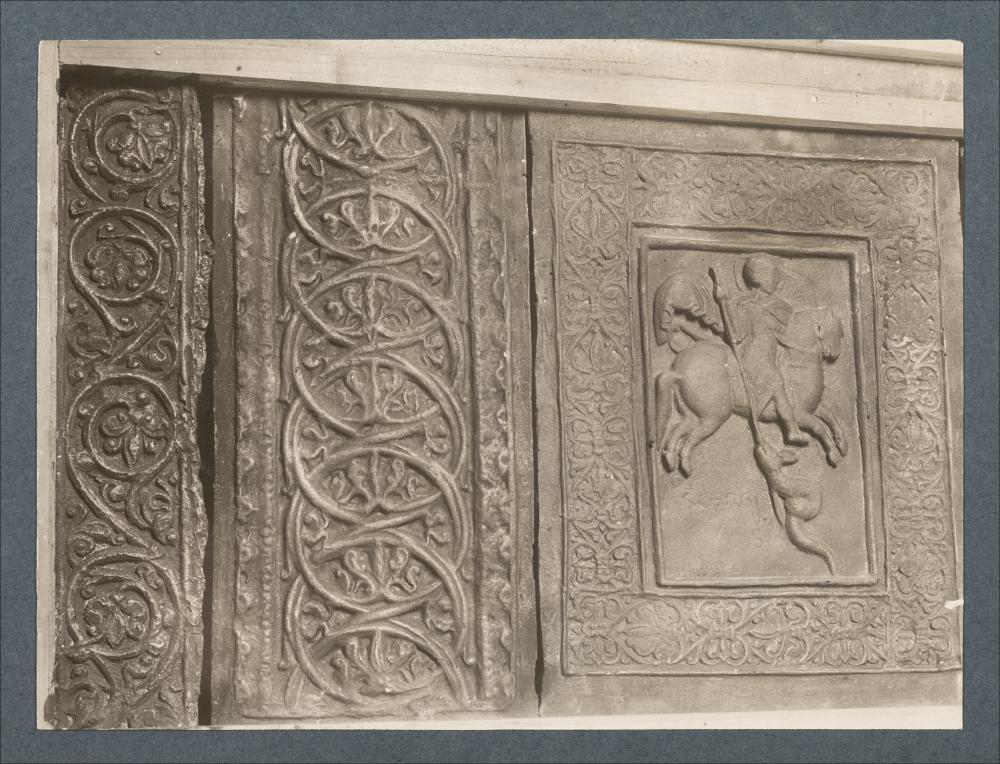 <div class="ql-editor"><div>Documentazione fotografica di una formella decorativa della porta bronzea della Cattedrale di Trani. La formella, risalente al XII secolo, è opera di Barisano da Trani, con San Giorgio e il drago e motivi decorativi a tralci vegetali.</div><div>L'immagine digitale fa parte della raccolta fotografica di Giuseppe Ceci (1863-1938), studioso delle arti figurative dell’Italia meridionale e tra i promotori delle Società di Storia Patria di Napoli e della Puglia. Tale raccolta si inserisce nel vivace clima culturale dell’Italia postunitaria, caratterizzato dal progressivo consolidarsi di una «coscienza nazionale» alimentata anche dal confronto e dal dialogo con le realtà storiche e culturali locali.</div><div>Ogg...