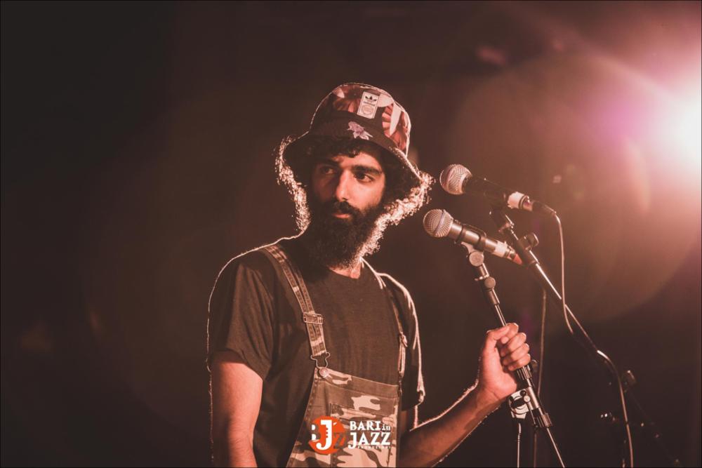 "Bari in Jazz" è un Festival Metropolitano con cadenza annuale, organizzato da Abusuan in Puglia, presenta concerti con ospiti nazionali ed internazionali. L’edizione 2018 del Festival Metropolitano "Bari in Jazz", la quattordicesima, è stata interamente dedicata alle figure femminili nella musica e nel jazz, nel canto, nella composizione e nell’arrangiamento, nell’uso dei vari strumenti e stili musicali. Come ogni anno il Festival Metropolitano Bari in Jazz, luogo d’incontro della musica jazz con altri generi musicali, offre una vetrina d’eccellenza alle grandi artiste e a quelle emergenti, promuovendo anche nuove creazioni. La fotografia mostra il cantante un attimo prima dell'esibizione, visibile a pieno l'emozione nello sguardo del soggetto. Tutta la scena è pervasa...