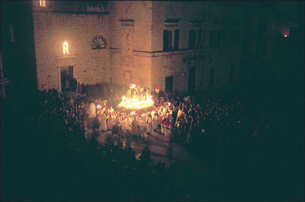 La fotografia è parte della ricca raccolta fotografica “Puglia per tutte le Stagioni” vol. 2, prodotta dall'Assessorato al Turismo e Industria Alberghiera della Regione Puglia e creata per raccontare la Puglia attraverso immagini diverse suddivise in 5 settori principali: Città e Paesi, Settimana Santa, Territorio, Feste – Sagre – Tradizioni, Mercati – Prodotti – Cucina. L'immagine digitale mostra l'uscita, alcune ore prima dell'alba del Giovedì Santo, della processione degli “Ottosanti” dalla porta della Chiesa di S. Rocco di Ruvo di Puglia. Alle 2:00, nella notte tra il mercoledì e il giovedì santo, in piazza Menotti Garibaldi, risuona l'esecuzione, da parte della banda musicale, della celeberrima marcia funebre "Una lagrima sulla tomba di mia madre", meglio nota come...