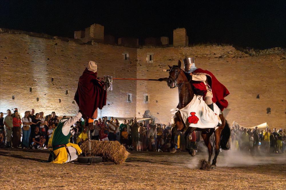 <div>La fotografia mostra il cavaliere in azione durante la <strong>Giostra del Saraceno</strong> di Lucera mentre colpisce con precisione il fantoccio del ‘Saraceno’, catturando il momento di tensione e abilità cavalleresca tipico di questa tradizione secolare. </div><div><br></div><div><strong>Giostra del Saraceno</strong>, dimostrazione pratica dell’antica competizione medioevale e degli spettacoli equestri. Il momento culminante vede il cavaliere colpire con precisione il fantoccio, simbolo del nemico, rievocando una prova di abilità cavalleresca tipica del Medioevo. La Giostra conclude la rievocazione storica con il terzo episodio, <strong>“La resa di Lucera”</strong>, che ripercorre la presa della città per fame e stent...