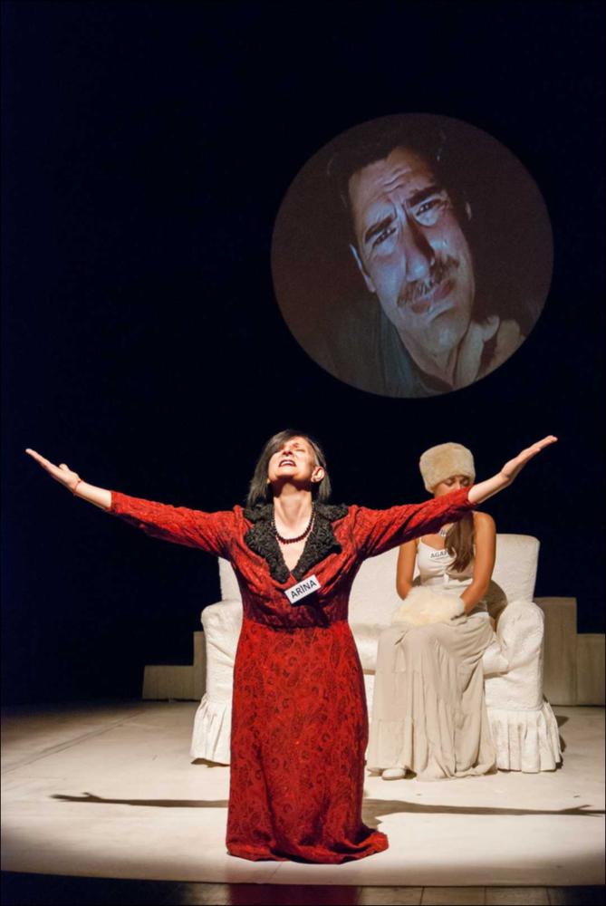 L'immagine in oggetto, fotografia digitale ad opera di Angela Chezzi, cattura un momento dello spettacolo “Il Matrimonio”, per la regia di Salvatore Tramacere, tratto dall'opera teatrale del 1842 di Nikolaj Vasil'evič Gogol', satira incentrata su una giovane donna, Agafija, corteggiata da quattro scapoli, ognuno con le sue eccentricità. Gli stessi personaggi vengono catapultati da Tramacere nel nostro tempo, portando con sé i lati più buffi e divertenti. Il palcoscenico ricorda un set di una trasmissione televisiva, con un presentatore che guida uomini e donne nella ricerca del partner, ma tutto risulta finto e lo schermo allontana ancor più i protagonisti, lasciandoli soli con le proprie inquietudini, aumentando così la distanza tra l'essere e l'apparire. Per far sposa...