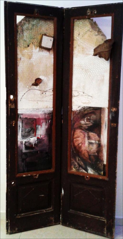 L'immagine digitale riproduce l'installazione realizzata dal pittore pugliese Franco Valente. Attivo sin dagli anni '60 del secolo scorso, Valente si pone da subito come promotore della conoscenza e delle arti istituendo nella sua città natale, Molfetta, il centro culturale “Il Cavalletto”. La sua esperienza artistica parte dunque dalla Puglia e si completa negli anni con le diverse partecipazioni a collettive e rassegne d'arte in Italia e all'estero. Noto per le sue installazioni di porte e finestre chiuse, rovinate e destrutturate, Franco Valente, attraverso la sua arte, rievoca un passato ormai decadente che prende vita con pennellate di colore molto spesso dai toni freddi e acidi. Valente è dunque un grande esempio di artista che crea le sue opere liberandosi da ogn...
