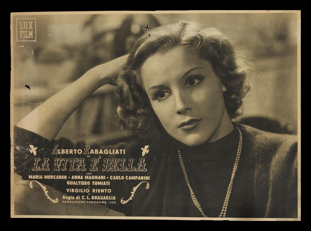 L'immagine riproduce il contenuto di una delle fotobuste conservate presso la Mediateca Regionale Pugliese (vedi Note). Si tratta di un soggetto del film “La vita è bella”, film in bianco e nero del 1943, per la regia di Carlo Ludovico Bragaglia. Colpisce il bellissimo primo piano pensieroso dell’attrice María Mercader, nel film Nadina....