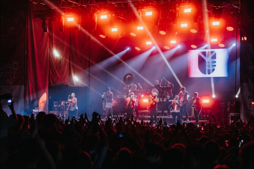 <div>Lo scatto racconta l’esibizione dei <strong>Meute</strong>, protagonisti della serata di chiusura della XX edizione del Locus Festival, il 14 agosto 2024 presso la Masseria Ferragnano di Locorotondo. Emblema dell’incontro tra suoni globali e scena musicale italiana, i Meute — la celebre “techno marching band” nata nelle strade anticonformiste del quartiere di St. Pauli ad Amburgo — sono rapidamente diventati un fenomeno mondiale. Al Locus hanno presentato il loro quarto album, <em>Empor</em>, regalando al pubblico un finale di festival travolgente.</div>...