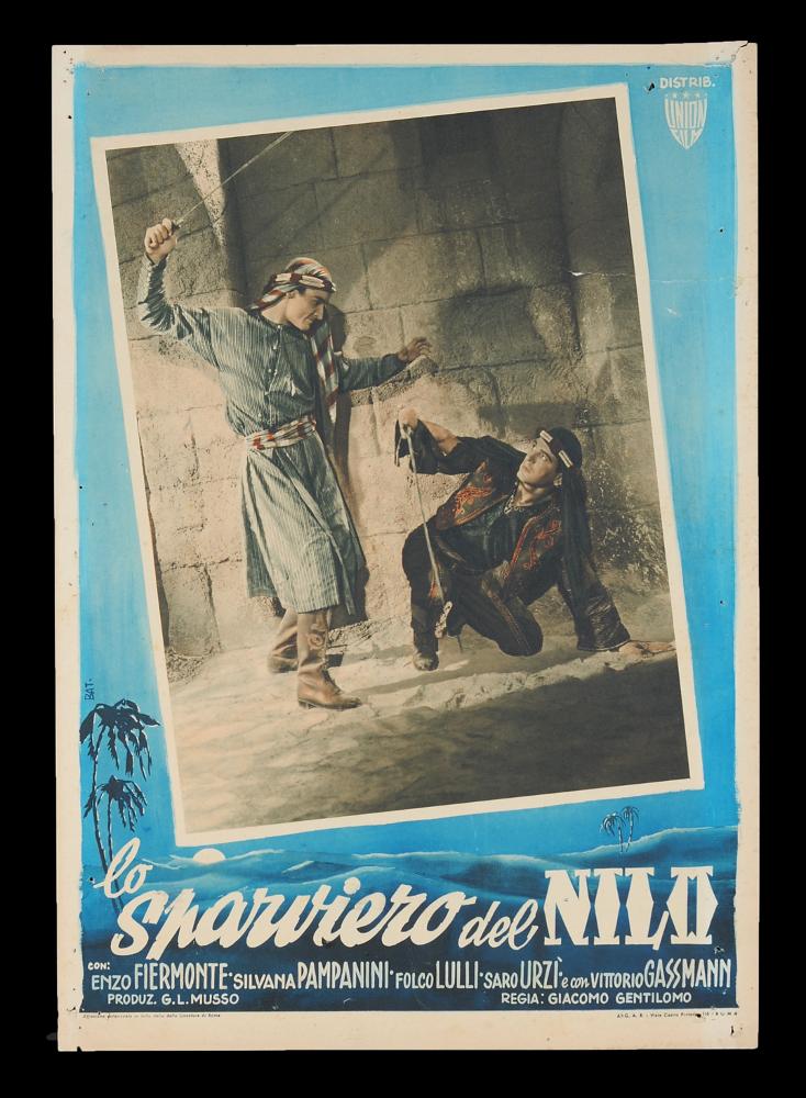 L'immagine riproduce uno dei manifesti conservati presso la Mediateca Regionale Pugliese (vedi Note). Si tratta di una delle fotobuste del film "Lo sparviero del Nilo", la cui composizione grafica è dell'illustratore Bat. (Giovanni Battaglia). La fotobusta riporta una delle scene più significative della pellicola italiana ambientata in Egitto, con colori accentuati (probabilmente realizzati a pittura prima della stampa) come era in voga all'epoca. Sono riconoscibili Vittorio Gassman ed Enzo Fiermonte, che anche se intenti in un duello, risultano figure eleganti che esaltano tutta la fotobusta. Intorno, una composizione dai toni blu intenso, a firma di Bat., riproduce un'ambientazione egiziana, calandola nell'atmosfera esotica del film....