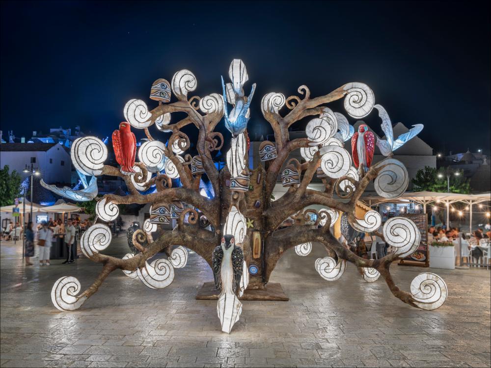 “L’albero della Vita – un seme che esplode” opera firmata dal maestro cartapestaio putignanese, Deni Bianco. Installazione artistica in cartapesta dove il tema dell’amore è rappresentato attraverso un grande albero luminoso che accoglie uccelli dal piumaggio colorato. L'installazione è parte del carro allegorico vincitore al Carnevale di Putignano 2019 “Chi è senza peccato scagli la prima mela”, ispirata all' ‘Albero della vita' di Gustav Klimt....