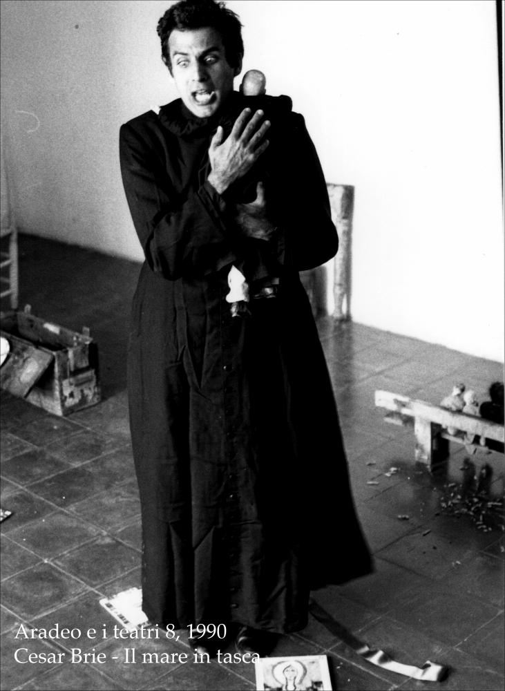La fotografia in bianco e nero cattura un momento intenso della rappresentazione teatrale “Il mare in tasca”, messa in scena nel 1990 dal Teatro Koreja, nell'ambito della rassegna annuale “Aradeo e i Teatri”, un appuntamento con il teatro sperimentale che la compagnia nata nel 1983 nel piccolo borgo salentino di Aradeo porta avanti sin dall'anno della sua fondazione. Rappresentato e replicato durante l'ottava edizione della più importante kermesse culturale e teatrale della Puglia dell'epoca, lo spettacolo fu prodotto dalla compagnia Koreja, insieme con l'autore e attore teatrale argentino César Brie, che lo scrisse e interpretò. Tutto si svolge in una stanza dietro la sagrestia di una chiesa, in un monologo che ha come tema l'amore, vissuto sotto diverse forme. La tram...