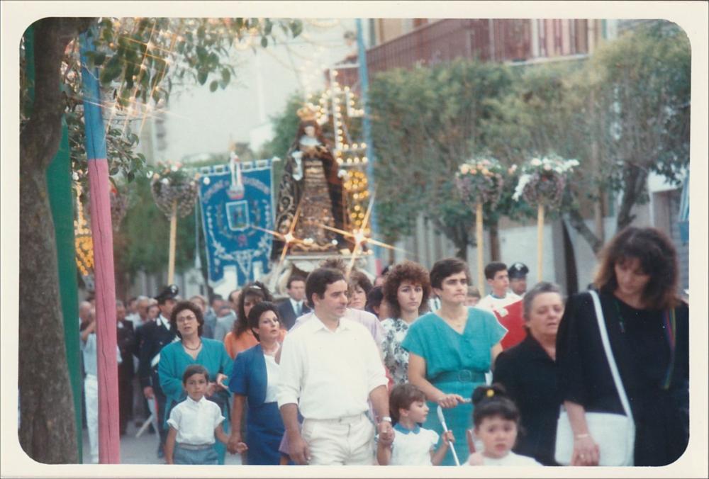 <div class="ql-editor"><div>La digitalizzazione di questa immagine cattura un momento solenne della Festa Patronale di Maria Santissima Addolorata a Poggiorsini: la statua della Madonna sfila in processione accompagnata da una folla di fedeli in preghiera.</div><div>La festa si celebra tradizionalmente il 9, 10 e 11 agosto. Secondo la tradizione orale, le sue origini risalgono alla prima metà del Novecento quando, a causa delle limitate risorse economiche, veniva organizzata ogni due o tre anni. Solo in tempi più recenti la festa è diventata un appuntamento annuale, consentendo una più stabile conservazione e trasmissione delle pratiche religiose.</div><div>La dimensione spirituale è centrale e si prepara già dal mese di luglio con momenti ...