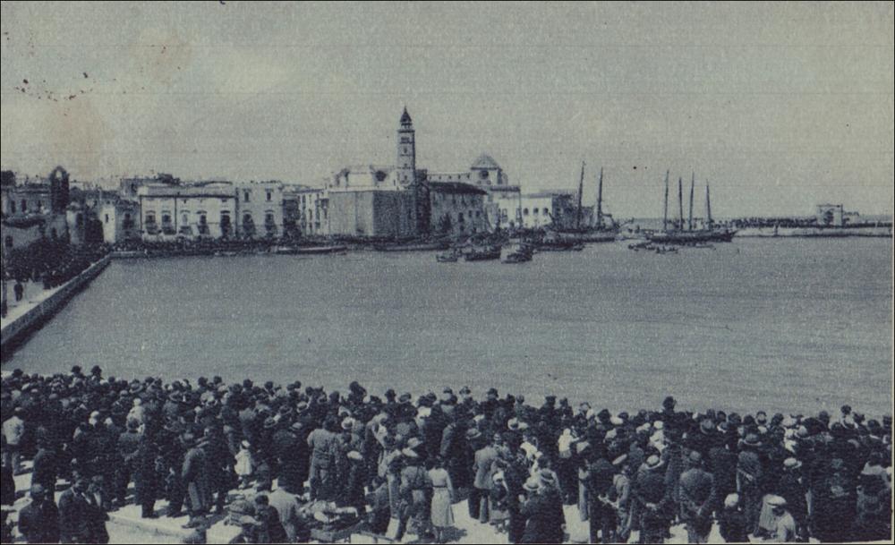 <div class="ql-editor"><div>Questa foto storica digitalizzata cattura un momento simbolico della Festa Patronale del Santissimo Crocifisso di Colonna celebrata negli anni '20 a Trani. Si tratta di uno degli appuntamenti religiosi e civili più sentiti dalla comunità di Trani (BT), espressione profonda della fede e dell’identità cittadina.</div><div>Fulcro della celebrazione è il venerato Crocifisso ligneo custodito nel Santuario di Colonna, legato a un prodigio risalente al 1480, epoca dell’invasione turca in terra d’Otranto e del martirio degli Ottocento Cristiani. Secondo la tradizione, il Crocifisso, trafugato da pirati saraceni, venne sfregiato sul volto e gettato in mare; miracolosamente, però, tornò a galleggiare fino...