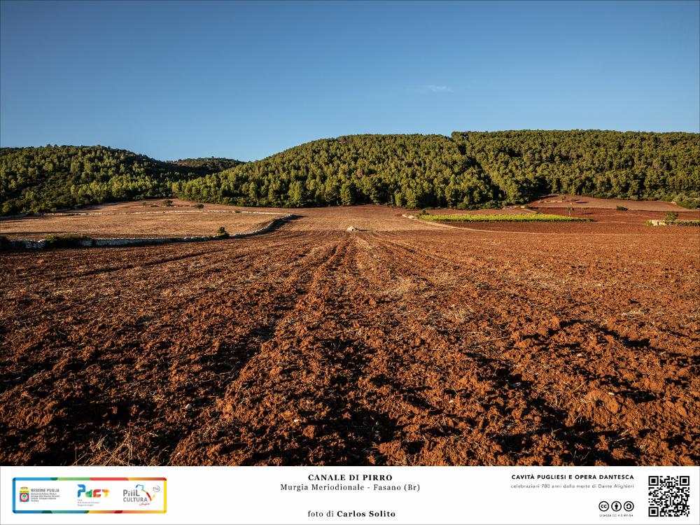 La fertile terra rossa del Canale di Pirro a Fasano, in provincia di Brindisi, una delle doline più grandi della Terra di Bari.
La quiete caratterizza questo paesaggio di campagna. Il colore vermiglio della terra accostato al verde intenso della rigogliosa vegetazione mediterranea e all’azzurro puro del cielo ci regala un quadro naturale di straordinaria bellezza.
Ampia tra i 500 e i 1.500 metri e profonda circa 100 metri, la dolina si allunga per 12 chilometri tra i territori dei comuni di Putignano, Castellana Grotte, Monopoli, Alberobello, Locorotondo e Fasano.
L’immagine digitale fa parte della raccolta di fotografie prodotte da Carlos Solito per il Progetto digitale “Sillabario sotterraneo – Viaggio dantesco nelle Grotte di Puglia” – realizzato nell’ambito della LE...
