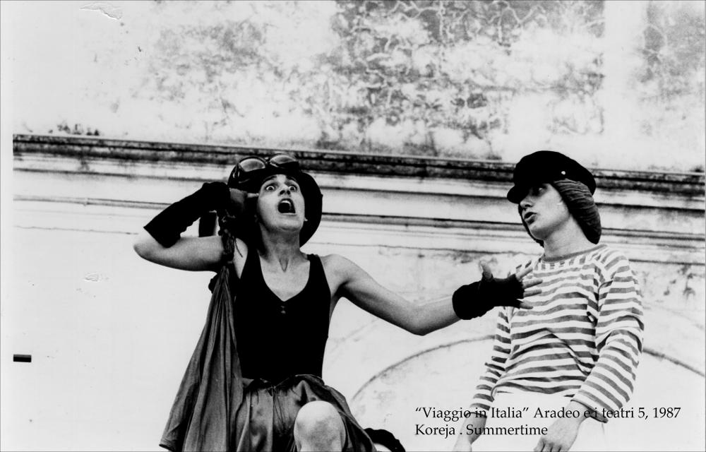 La fotografia in bianco e nero cattura un momento dello spettacolo “Summertime”, messo in scena nel 1987, nell'ambito della rassegna annuale “Aradeo e i Teatri”, un appuntamento con il teatro sperimentale che la compagnia Koreja, nata nel 1983 nel piccolo borgo salentino di Aradeo porta avanti sin dall'anno della sua fondazione. La performance ebbe come palcoscenico il suggestivo cortile del Castello "Tre Masserie", una struttura residenziale degli inizi del XX secolo situato tra gli ulivi della campagna di Aradeo. I personaggi principali della rappresentazione sono “vittime” di un mènage a tre durante le vacanze estive. Una spiaggia, due ragazze terribili e un ragazzo che, pur essendo fortemente attratto da loro, tenta in ogni modo, quasi con disperazione, di allontana...