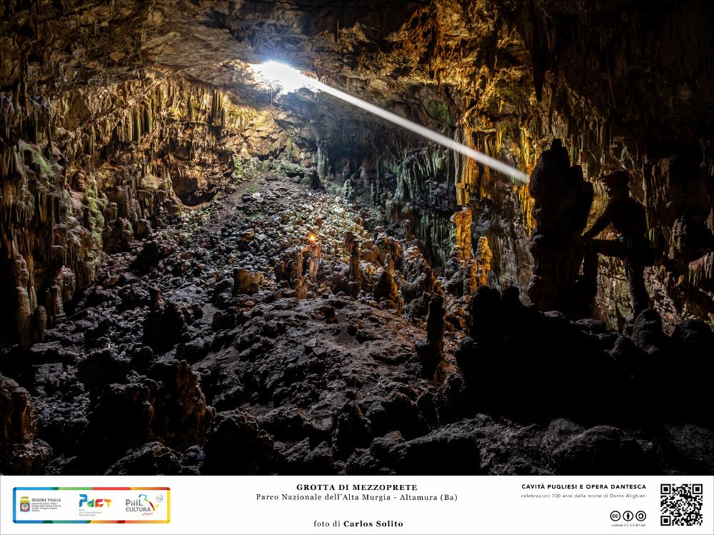 La Grotta di Mezzoprete è una delle caverne più grandi e suggestive del Parco Nazionale dell’Alta Murgia, nei pressi di Altamura.  
Un pozzo di circa 10 metri dà accesso alla enorme caverna: le possenti pareti rocciose sono ricche di concrezioni stalagmitiche mentre dal basso si levano formazioni più massicce. Sulla superficie un’apertura si spalanca come un occhio a illuminare e scaldare la vastità dell’ambiente.
L’immagine digitale fa parte della raccolta di fotografie prodotte da Carlos Solito per il Progetto digitale “Sillabario sotterraneo – Viaggio dantesco nelle Grotte di Puglia” – realizzato nell’ambito della LEGGE REGIONALE 30 dicembre 2020, n. 35 - art. 39 “Cavità pugliesi e opera dantesca - Celebrazioni 700 anni dalla morte di Dante Alighieri”.