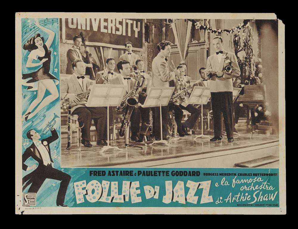 L'immagine riproduce uno dei manifesti conservati presso la Mediateca Regionale Pugliese (vedi Note). Si tratta di uno dei soggetti della fotobusta del film "Folli di jazz", a firma di Longi (Lon.). L'artista firma tutta la serie della fotobusta, con uno stile vivace e illustrativo, molto dinamico e fresco, che accompagna le diverse scene del film. Nella sua vita artistica, Carloantonio sperimentò diversi stili: dal più tradizionale sfumato policromo e narrativo alla sintesi grafica più contemporanea fatta di pochi colori e tratti, come in questo caso, in cui riesce a rappresentare e a dare dinamicità ai personaggi. Sulla scia delle note blu, infatti, si riconoscono Fred Astaire che suona la tromba e Paulette Goddard che balla. Longi esalta così anche la figura femminil...