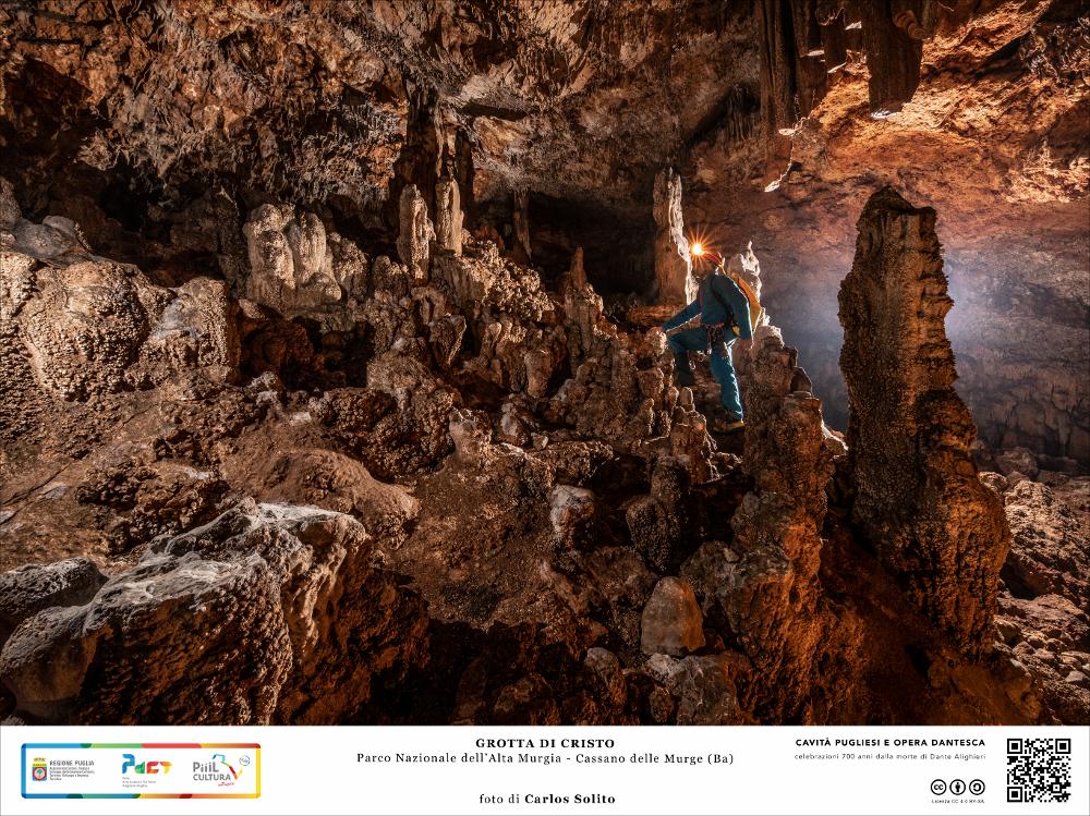 La fotografia immortala il percorso tortuoso tra le stalagmiti alla luce di una torcia. La grotta venne scoperta alla fine del XVII secolo e si trova quasi sull'orlo di una dolina in territorio boscoso, chiamato "Parco di Cristo", da qui il nome della cavità, che rappresenta per le sue abbondanti concrezioni alabastrine ed i colonnati, la più bella grotta della zona.
L’immagine digitale fa parte della raccolta di fotografie prodotte da Carlos Solito per il Progetto digitale “Sillabario sotterraneo – Viaggio dantesco nelle Grotte di Puglia” – realizzato nell’ambito della LEGGE REGIONALE 30 dicembre 2020 - art. 39 “Cavità pugliesi e opera dantesca - Celebrazioni 700 anni dalla morte di Dante Alighieri”.