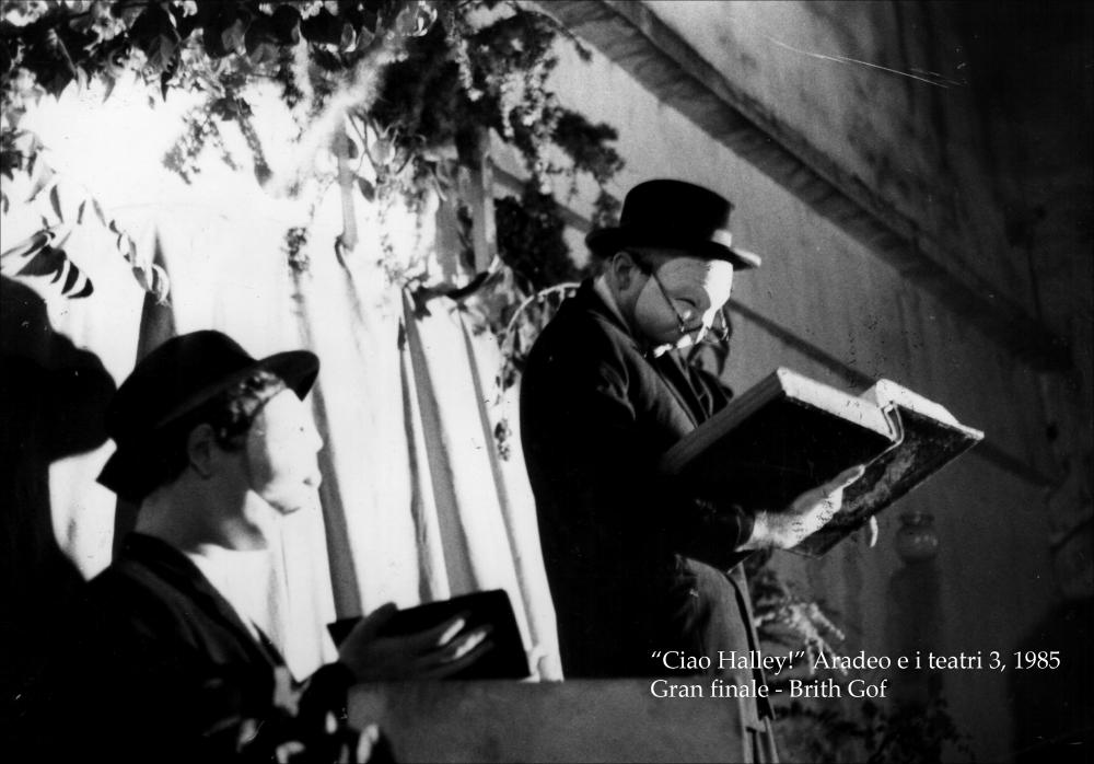 La fotografia immortala un momento dello spettacolo “Immigrants”, messo in scena nel 1985 nell'ambito della rassegna annuale “Aradeo e i Teatri” giunta alla terza edizione con il titolo “Ciao halley - festeggiamenti per l'arrivo di una cometa”, un appuntamento con il teatro sperimentale che la compagnia nata nel 1983 nel piccolo borgo salentino di Aradeo porta avanti sin dall'anno della sua fondazione. Durante la seconda serata della manifestazione, la compagnia gallese Brith Gof ha proposto, nella palestra comunale, la performance “Ymfudwyr”, in gallese. La trama è un intreccio di fonti: si passa dalla lettura di testi biblici a testimonianze contenute in lettere e diari di gallesi emigrati in America e Patagonia per sfuggire alla persecuzione religiosa e politica nel ...