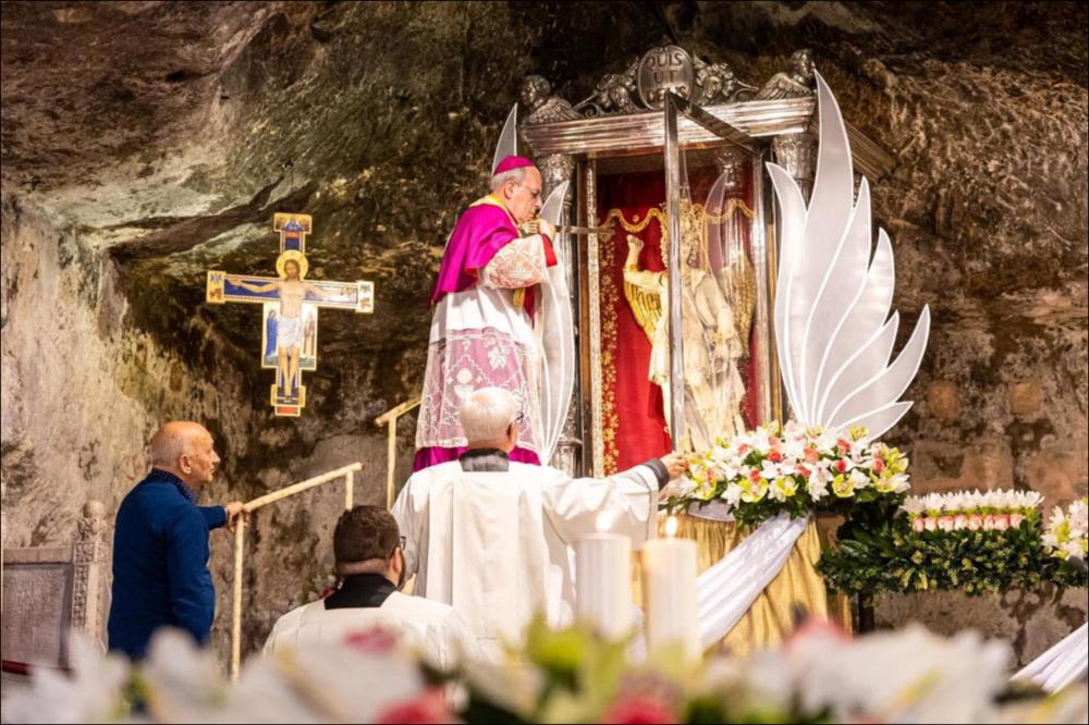 L’immagine immortala il momento in cui il vescovo si avvicina alla statua del Santo Patrono per estrarre la Sacra Spada e dare inizio al celebre Rito.
Il “Rito della Sacra Spada” viene celebrato il 29 settembre all’interno della Grotta del Santuario. L’estrazione della spada dalla statua rappresenta un gesto fortemente simbolico e richiama la Parola di Dio capace di distinguere il bene dal male e di offrire protezione e guarigione spirituale ai fedeli. La reliquia viene poi portata in processione come segno di devozione e di affidamento.
La festa patronale di Monte Sant’Angelo, dedicata a San Michele Arcangelo e celebrata il 29 settembre con riti che si estendono nei giorni precedenti e successivi, è tra gli eventi religiosi e culturali più significativi della Puglia. L...