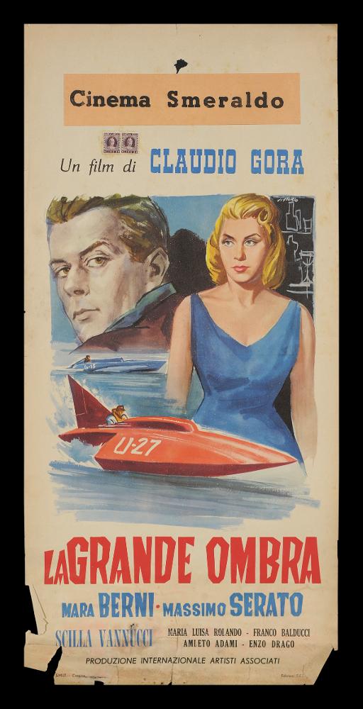 L'immagine riproduce uno dei manifesti conservati presso la Mediateca Regionale Pugliese (vedi Note). Si tratta di una delle locandine del film “La grande ombra”, del 1957, per la regia di Claudio Gora. L’illustrazione, a firma di Vittorio, presenta una scena del film ambientata in mare con due imbarcazioni e, sproporzionata rispetto allo sfondo, si innalza la figura intera di Mara Berni che interpreta la bellissima centralinista Luciana. Alle spalle il ritratto molto realistico di Massimo Serrato nei panni del campione di motonautica Franco Donati. La composizione è molto semplice e l’artista utilizza colori delicati e sfumati....