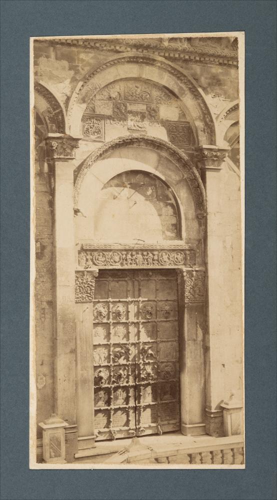 <div class="ql-editor"><div>Ritaglio da fotografia di Romualdo Moscioni del portale della Cattedrale di Troia (XII secolo).</div><div>L'immagine digitale fa parte della raccolta fotografica di Giuseppe Ceci (1863-1938), studioso delle arti figurative dell’Italia meridionale e tra i promotori delle Società di Storia Patria di Napoli e della Puglia. Tale raccolta si inserisce nel vivace clima culturale dell’Italia postunitaria, caratterizzato dal progressivo consolidarsi di una «coscienza nazionale» alimentata anche dal confronto e dal dialogo con le realtà storiche e culturali locali.</div><div>Oggi la Biblioteca Comunale di Andria conserva oltre settecento fotografie dedicate alla Puglia medievale, a Napoli e al patrimonio storico-artisti...