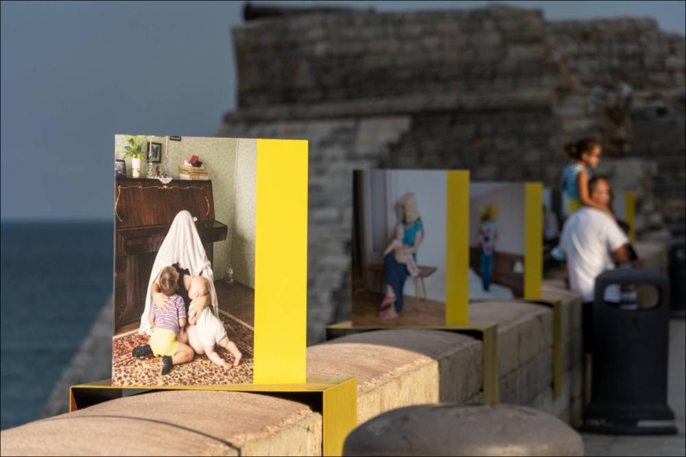 Il lungomare Santamaria, elemento di congiunzione delle coste di Monopoli che raggiunge lo storico Castello di Carlo V, diventa una galleria fotografica con forte richiamo sociale per l’artista Alena Zhandarova (1988, Birobidzhan, Russia), giovane artista russa. Il suo progetto “Hidden Motherhood” vuole far riflettere sul ruolo della donna/madre nella società. I suoi soggetti sono velati così come sono messi sotto un velo le difficoltà e i bisogni della figura femminile. Sono piccole riproduzioni che confrontano il lavoro di Alena con le foto vittoriane (XIX sec.), dove i soggetti principali erano i bambini e non le madri che venivano, nello stesso modo, nascoste....
