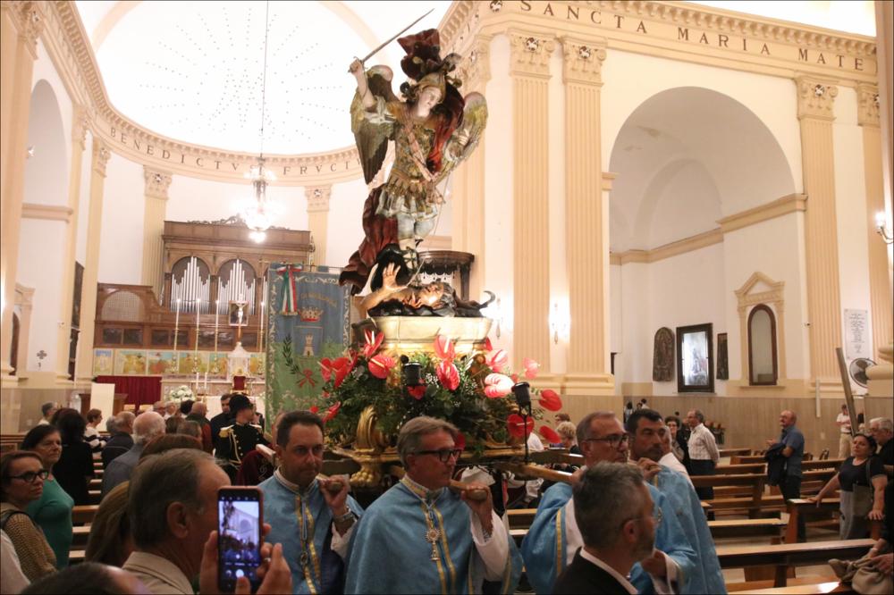 Realizzata nel 2025, l’immagine cattura l’istante solenne in cui la maestosa statua di San Michele Arcangelo lascia il Duomo di Massafra per prendere parte alla processione della Festa Patronale.
Il culto di San Michele, ufficializzato nel 1721 ma presente già da secoli, affonda le sue origini in antiche devozioni legate anche alla storica grotta carsica dedicata all’Arcangelo in zona Varcaturo, luogo di culto e testimonianza di riti e credenze tra epoche preclassiche e cristiane. Raffigurato come guerriero celeste, simbolo di protezione e giustizia, il santo è al centro di riti, opere d’arte, leggende e pratiche popolari che si tramandano di generazione in generazione, rafforzando il senso di appartenenza e coesione sociale.
Nonostante periodi di sospensione, la festa ...