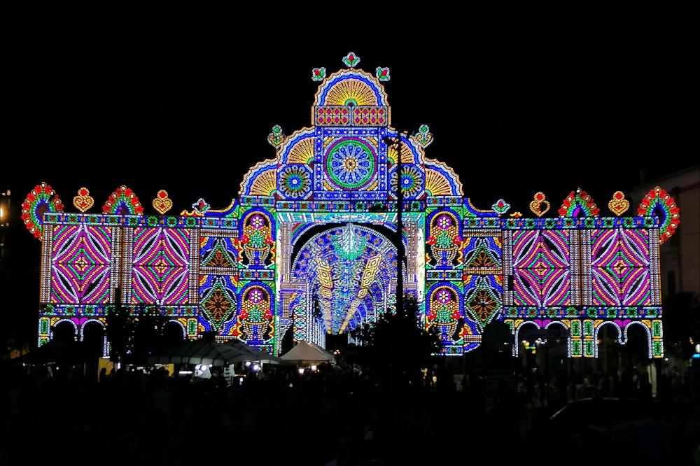 <div class="ql-editor"><div>Lo scatto fotografico immortala le suggestive luminarie allestite nella città di Mesagne (BR) in occasione della Festa Patronale della Madonna del Carmine.</div><div>La Festa Patronale della Madonna del Carmine, celebrata dal 15 al 17 luglio fin dal 1651, è uno degli eventi più significativi per la comunità. Non è soltanto una ricorrenza religiosa, ma un rito collettivo che rinnova ogni anno tradizioni, legami e identità.</div><div>Il 15 luglio si svolge la solenne processione che accompagna il simulacro della Vergine dalla Basilica del Carmine alla Chiesa Matrice, alla presenza di confraternite, autorità religiose e civili, bande musicali e numerosi fedeli. In Piazza Porta Grande si tiene il tradizionale di...