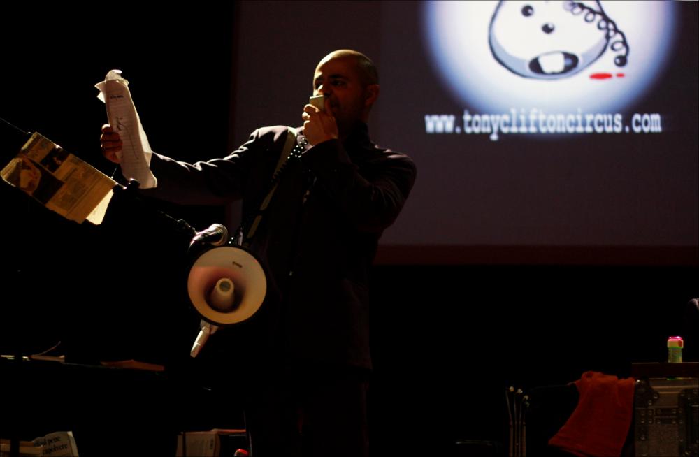 L'immagine fa parte di “Primavera dei Diritti", collezione digitale che raccoglie foto e video dell'omonima manifestazione promossa dalla Regione Puglia - Assessorato al Mediterraneo e realizzata dal Teatro Pubblico Pugliese dal 18 al 28 febbraio 2010 a Bari. La fotografia immortala un momento della performance “Me da igual”, messa in scena dal Tony Clifton Circus, sul palcoscenico del Teatro Kursaal, il 20 febbraio. La compagnia nasce nel 2001 dall'incontro con Anthony Jerome Clifton, artista italoamericano, presentandosi da subito come “circo dell'anomalia”. Composto da due clown, Nicola Danesi de Luca e Iacopo Fulgi, e da Enzo Palazzoni polistrumentista, il gruppo cerca di mettere in scena la stranezza e l'anomalia. Da questa premessa nascono i loro spettacoli, veri ...