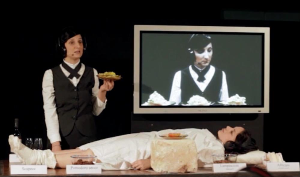 Il video in oggetto è il promo di “Il pasto della Tarantola”, spettacolo messo in scena dai Cantieri Teatrali Koreja di Lecce per la stagione 2015-2016. Con un format originalissimo e all'avanguardia, la rappresentazione teatrale punta a coinvolgere lo spettatore nella scoperta dei sapori tipici salentini. Mùscari, scapèce, pomodori secchi sott'olio, africani e il vino negramaro ornano una tavola dove una delle attrici è distesa silenziosamente, mentre l'altra comincia il racconto dei prodotti tipici e guida il pubblico in una degustazione individuale. Il Salento emerge in tutta la sua forza e fascino, anche nel racconto di un fenomeno, ancora tutto da studiare, che segnò il passato di questa terra: il tarantismo. "Rosaria è stata punta per la prima volta a 13 anni" nar...