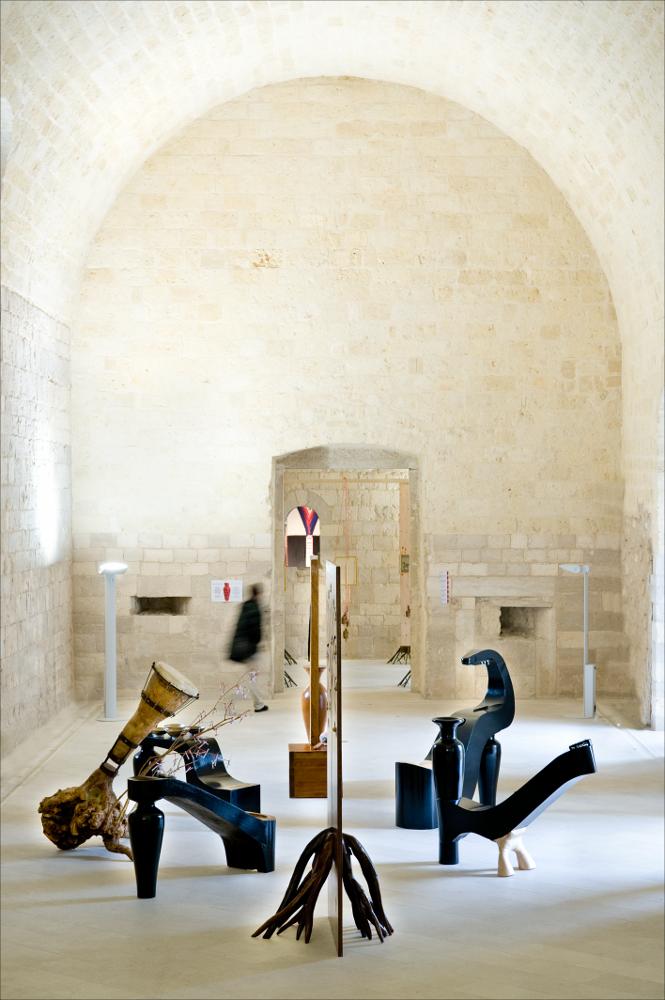 L'immagine digitale è una fotografia grandangolare di Cosmo Laera che ritrae una delle installazioni create dall'artista pugliese Tarshito per la mostra temporanea ed itinerante “Le culture sacre dell'Arte". Fu esposta dal 23 novembre 2008 al 25 gennaio 2009 nel Castello di Trani, successivamente a Milano nei mesi di febbraio e marzo, nei Chiostri di San Simpliciano, Facoltà Teologica dell'Italia Settentrionale, Accademia di Belle Arti di Brera, nel mese di giugno nell'Ex Chiesa di S. Francesco, presso l'Assessorato alla Cultura del Comune di Como. L'artista, al secolo Nicola Strippoli, architetto, designer e docente di Design all'Accademia di Belle Arti di Bari concepisce delle installazione in perfetta armonia estetica e filosofica con gli spazi del Castello di Trani,...