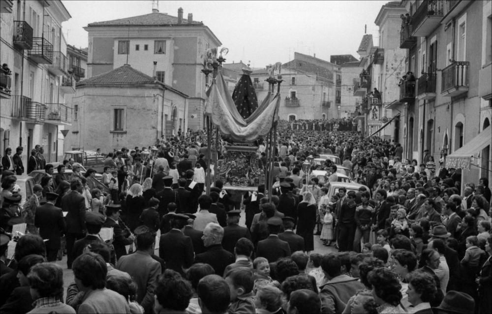 <div class="ql-editor">Siamo nel 1979, durante la Festa Patronale di Maria SS.ma Addolorata a San Marco in Lamis. La fotografia ci mostra la processione che avanza per le vie del paese, con la folla raccolta lungo le strade. Siamo alle spalle del simulacro della Madonna, che guida il corteo religioso, portata a spalla da fedeli. Intorno, uomini, donne e bambini la seguono con devozione; le confraternite e le autorità civili e religiose completano il corteo. 
<div><br>La Festa Patronale di Maria SS.ma Addolorata a San Marco in Lamis si celebra ogni anno dal 19 al 21 settembre, con il culmine religioso il 21. La festa combina riti religiosi – celebrazioni eucaristiche, settenario e processione della statua della Madonna – con momenti civili e cultural...