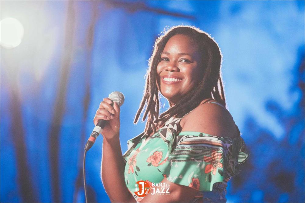 "Bari in Jazz" è un Festival Metropolitano con cadenza annuale, organizzato da Abusuan in Puglia, presenta concerti con ospiti nazionali ed internazionali. L’edizione 2018 del Festival Metropolitano "Bari in Jazz", la quattordicesima, è stata interamente dedicata alle figure femminili nella musica e nel jazz, nel canto, nella composizione e nell’arrangiamento, nell’uso dei vari strumenti e stili musicali. Come ogni anno il Festival Metropolitano Bari in Jazz, luogo d’incontro della musica jazz con altri generi musicali, offre una vetrina d’eccellenza alle grandi artiste e a quelle emergenti, promuovendo anche nuove creazioni. La fotografia mostra la cantante con lo sguardo diretto alla camera, mentre sorride....