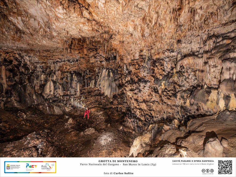 La fotografia ritrae la caverna centrale della grotta di Montenero, una vasta caverna di crollo cementata da colate calcitiche, che conduce a cunicoli e salette. Le volte e le pareti di questi ampi spazi, detti “cameroni”, sono arabescate da stalattitiche concrezioni, le quali formano gallerie, cupole, alberi ed altre bizzarre figure.
L’immagine digitale fa parte della raccolta di fotografie prodotte da Carlos Solito per il Progetto digitale “Sillabario sotterraneo – Viaggio dantesco nelle Grotte di Puglia” – realizzato nell’ambito della LEGGE REGIONALE 30 dicembre 2020 - art. 39 “Cavità pugliesi e opera dantesca - Celebrazioni 700 anni dalla morte di Dante Alighieri”.
