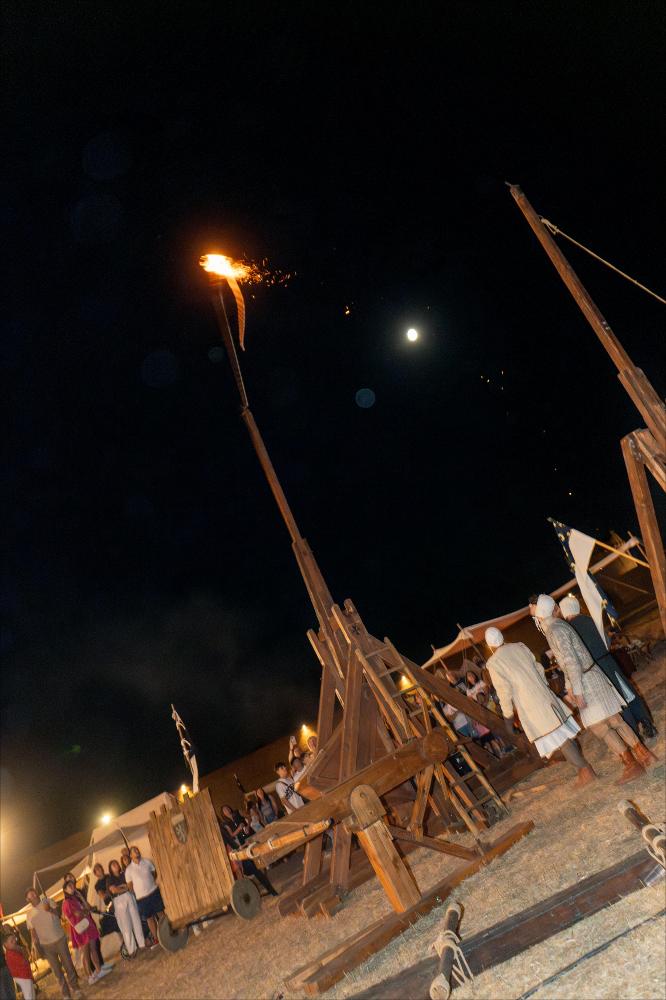 <div><strong>Lancio della palla infuocata con il trabucco durante il Villaggio Medioevale di Lucera 2025.</strong></div><div>L’azione è parte della rievocazione storica <em>“1268-1269 – L’assedio angioino di Lucera”</em>, ospitata dall’8 al 10 agosto all’interno della Fortezza Svevo-Angioina, trasformata in scenografia vivente del Duecento. Il Villaggio Medioevale ha ricostruito accampamenti militari, vita quotidiana e tecniche belliche del XIII secolo, culminando ogni sera con il lancio simbolico della palla infuocata dal trabucco, elemento scenografico e narrativo della rievocazione dell’assedio alla <em>Luceria Saracenorum</em>.</div><div><br></div><div>Dall’8 al 10 agosto 2025, la Fortezza Svevo-Angioina di ...
