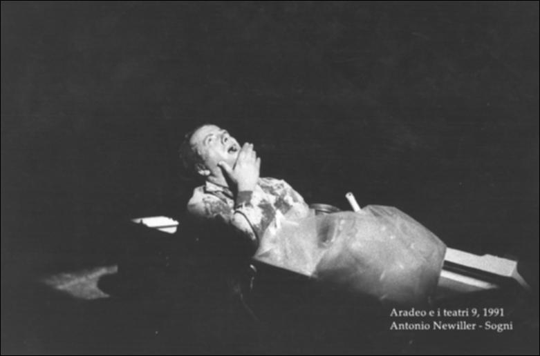 La fotografia in bianco e nero è un momento dello spettacolo "Sogni", rappresentato nel 1991 da Antonio Neiwiller durante la nona edizione di "Aradeo e i Teatri", un appuntamento con il teatro sperimentale che la compagnia Koreja nata nel 1983 nel piccolo borgo salentino di Aradeo porta avanti sin dall'anno della sua fondazione. Lo spettacolo fu proposto come evento speciale ed esclusivo per la prima volta proprio in quell'anno, insieme a "Sfigurato" di Alfonso Santagata. "Sogni" è l'idea di Sud di Neiwiller, che semisepolto nella terra e ricoperto di rifiuti come un barbone narra lamentoso storie e microstorie di rabbia e infelicità permanente fondata sul sopruso. La suggestione di un mondo sempre più degradato (per l'ambiente e gli umani indistintamente) è data da una...